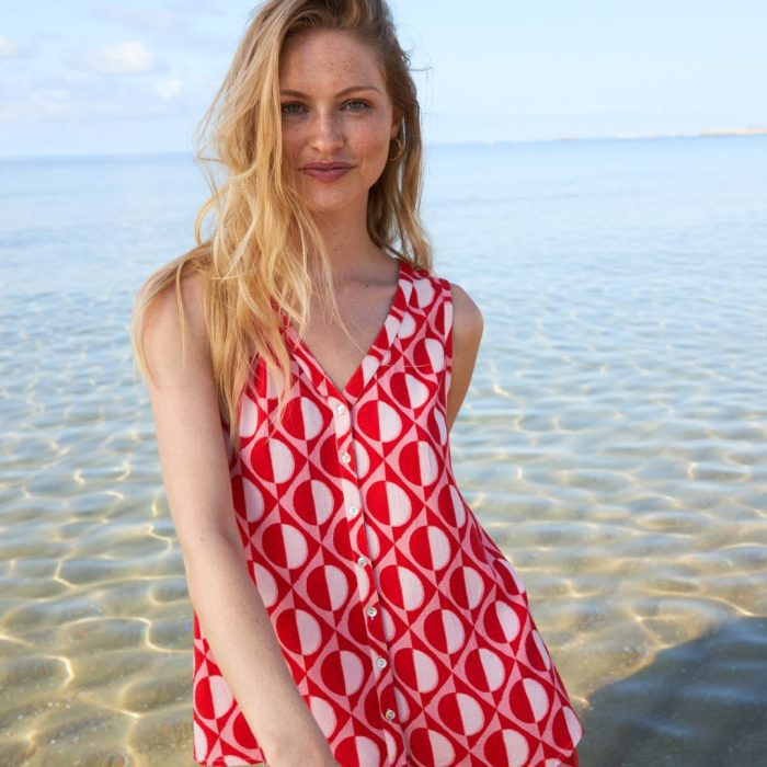 Mujer con vestido rojo de estampado geométrico de Miss Tachuelas en la playa de Málaga