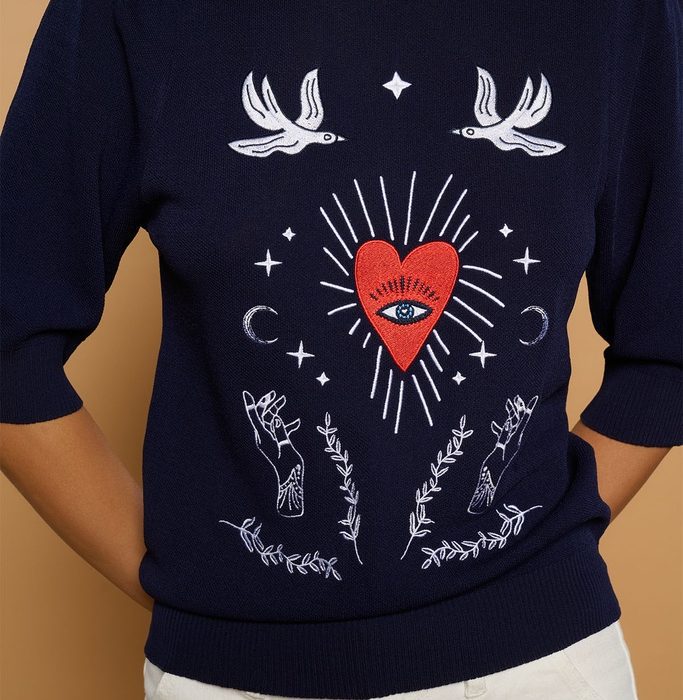 Jersey de punto azul marino con bordado de corazón rojo con ojo, aves, estrellas y manos en estilo místico