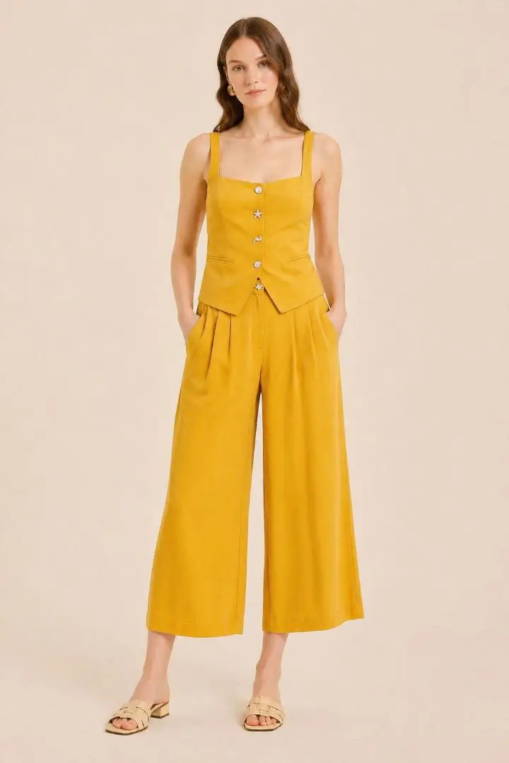 Culote con pinzas amarillo Pepaloves, de tiro alto y pernera amplia con botón joya metálico de estrella de mar.