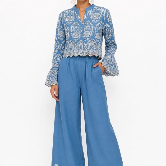 Conjunto de algodón azul cielo para mujer compuesto por chaqueta torera bordada con manga acabada en volante y pantalón fluido de pernera ancha con bordado blanco en el bajo.