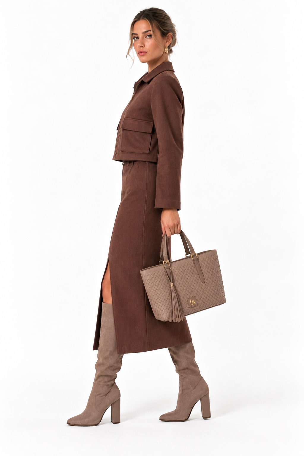 Vista lateral del conjunto de ante marrón chocolate Don Algodón con chaqueta corta, falda midi y bolso Palma taupe.